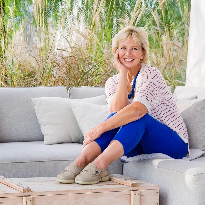 Woman sitting on settee shoes on box